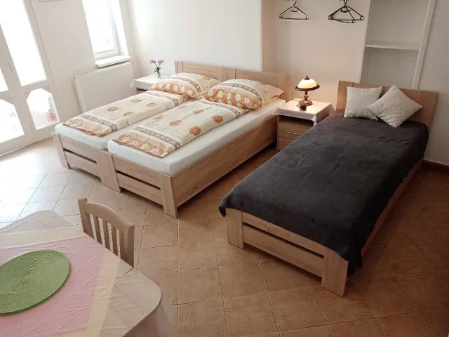 Apartmán s postelemi, stolem a velkým oknem